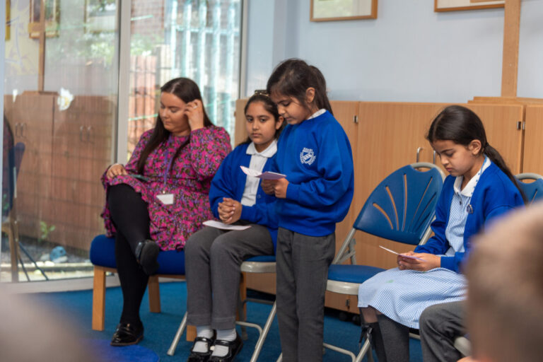 a picture of a student reading to a class