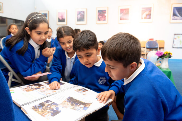 a picture of students looking at a book