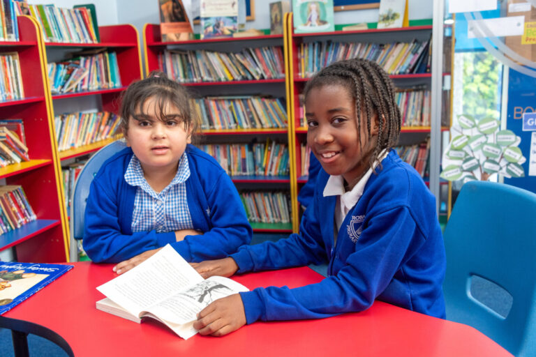 a picture of two students reading a book