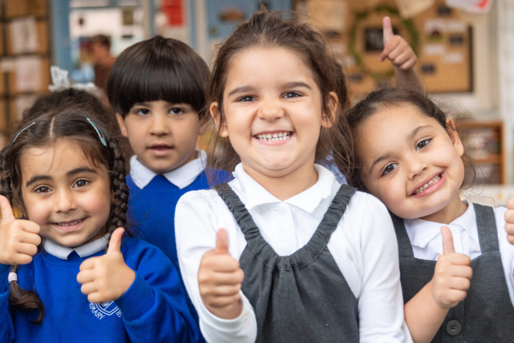 a picture of a group of students with their thumbs up