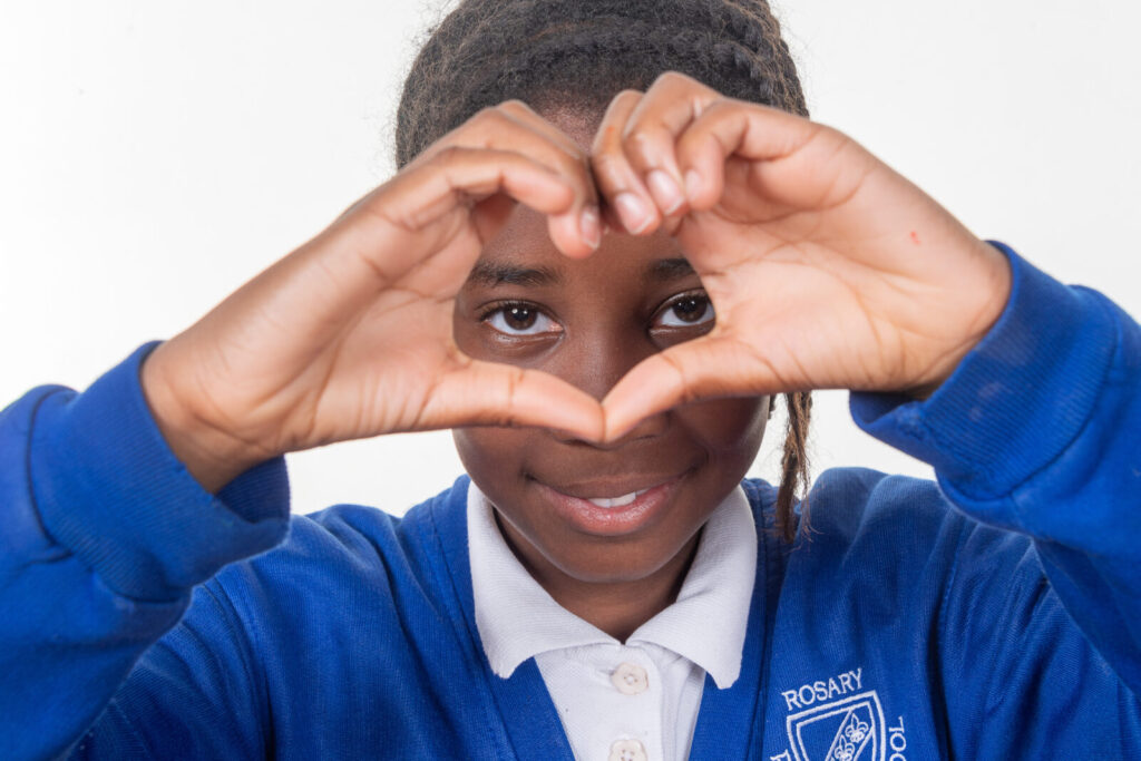 a picture of a student doing a heart with their hands